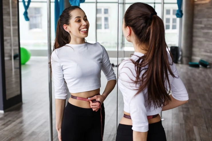 happy woman looks herself mirror holding tape measure her waist 8353 5524 (2) happy woman looks herself mirror holding tape measure her waist 8353 5524 (2)
