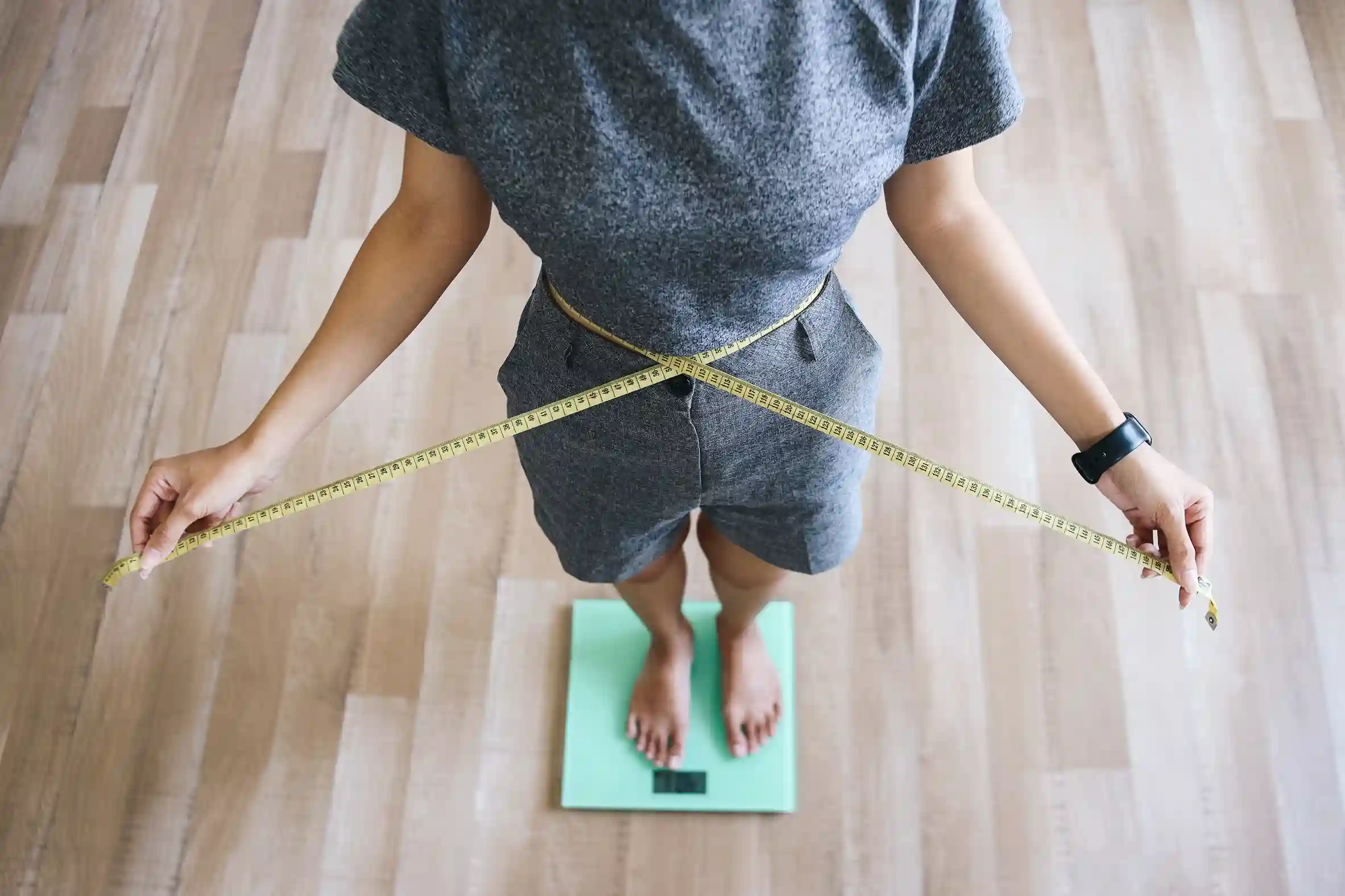 woman measures waist while standing on scale 2026 03 24 07 57 56 utc 11zon woman measures waist while standing on scale 2026 03 24 07 57 56 utc 11zon