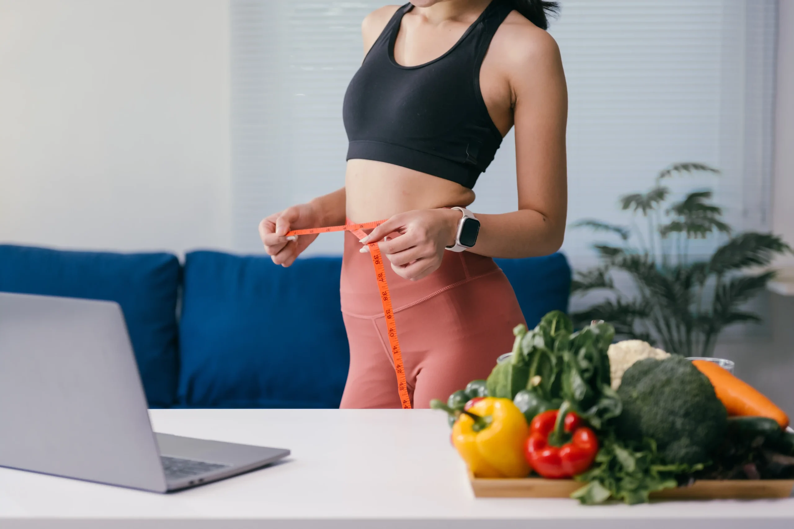 woman measures waist with vegetables and laptop 2026 01 07 06 36 39 utc 11zon woman measures waist with vegetables and laptop 2026 01 07 06 36 39 utc 11zon